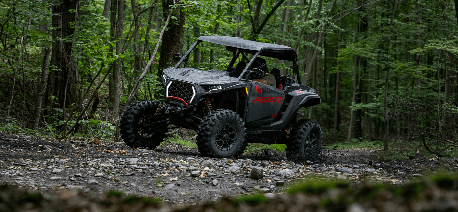 Off-road vehicle on a dirt path in a forest