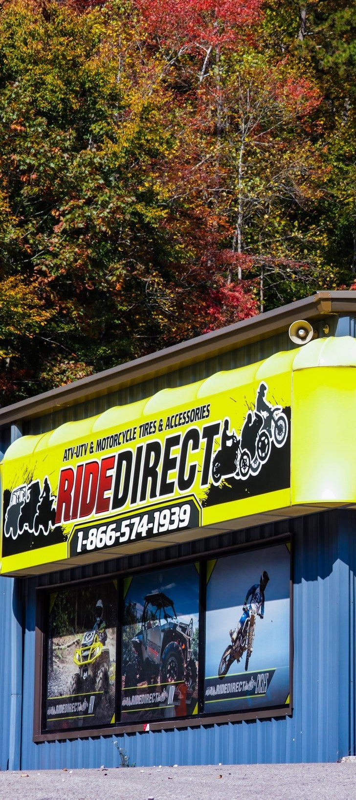 Ride Direct store exterior with colorful sign and autumn trees in the background