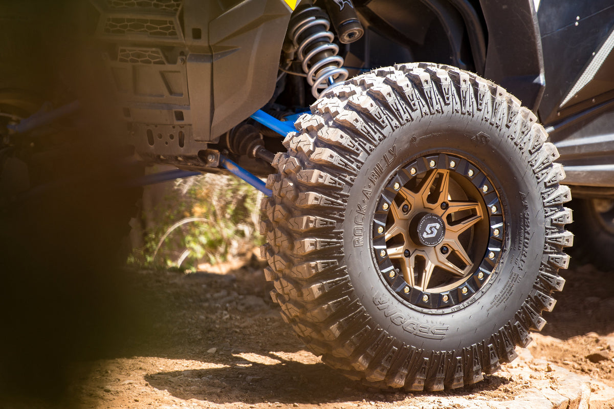 Close-up of a rugged off-road tire with a detailed tread pattern on a vehicle.