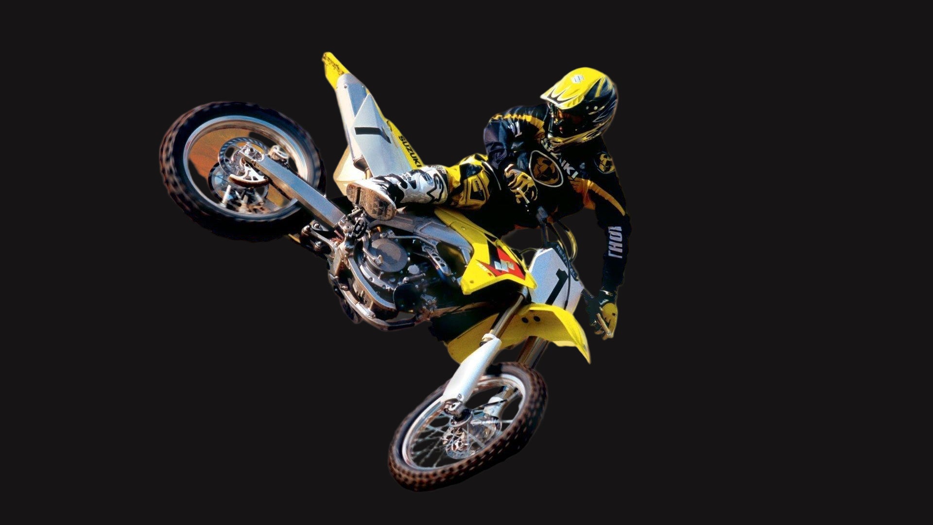 Motorcyclist performing a stunt against a dramatic sunset sky